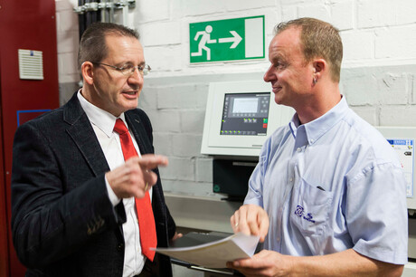 Inżynier KAESER KOMPRESSOREN, Hages, oraz pracownik ZF Friedrichhafen, Baumgarten, rozmawiają o planach stacji sprężonego powietrza