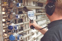 Technik serwisu KAESER KOMPRESSOREN z pomiarowym urządzeniem ultradźwiękowym w poszukiwaniu nieszczelności.